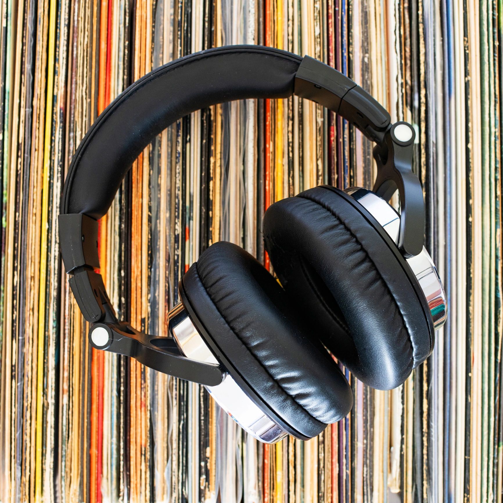 headphones resting on a stack of vinyl records. Top view.